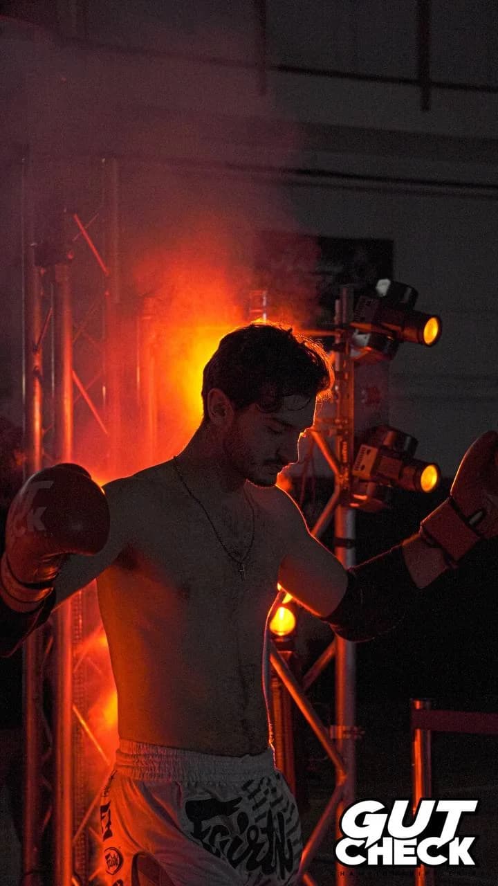 A fighter makes an intense walkout under fireworks at Gut Check Championship Series in Delaware, preparing for a high-stakes Muay Thai fight.