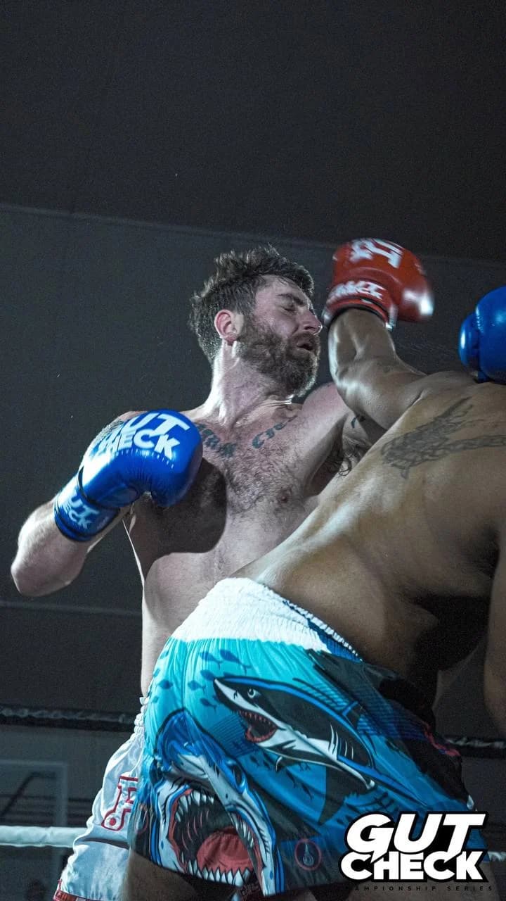 A Muay Thai fighter throws a powerful punch during a high-energy bout at Gut Check Promotions in Delaware.